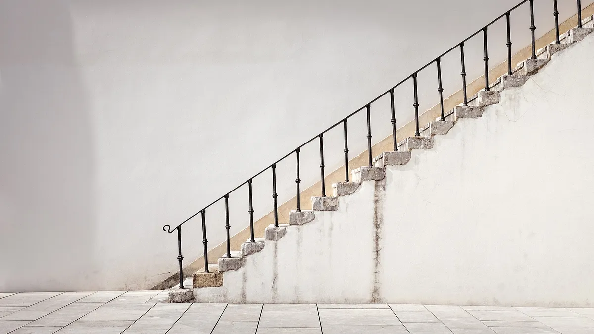 Une personne qui monte un escalier, symbole de progression par étapes