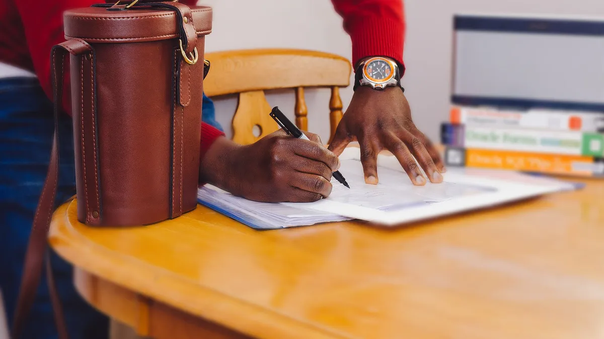 A student writing an essay by hand in a quiet exam hall